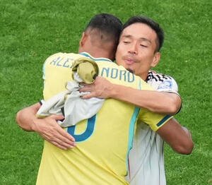 ブラジルのアレックスサンドロと抱き合う長友佑都(AP)