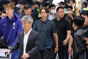 帰国した韓国代表と監督を辞任した洪明甫氏(中央、AP)