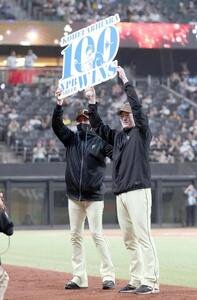 日本ハム対オリックス　NPB通算100勝を達成し記念ボードを新庄剛志監督(左)と掲げる有原航平(撮影･黒川智章)