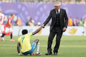 敗戦し、ピッチに座り込んだブラジルFWビニシウスに手を差し伸べるアンチェロッティ監督(AP)
