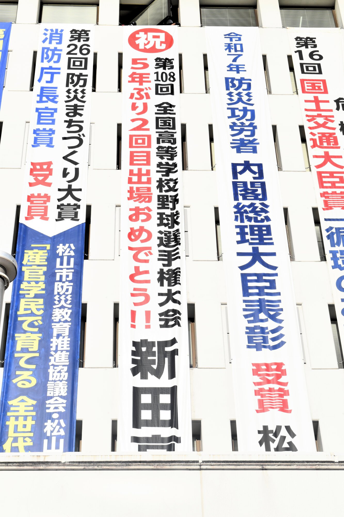 掲げられた新田を応援する懸垂幕=2026年7月30日午後5時35分、松山市役所、宮沢崇志撮影