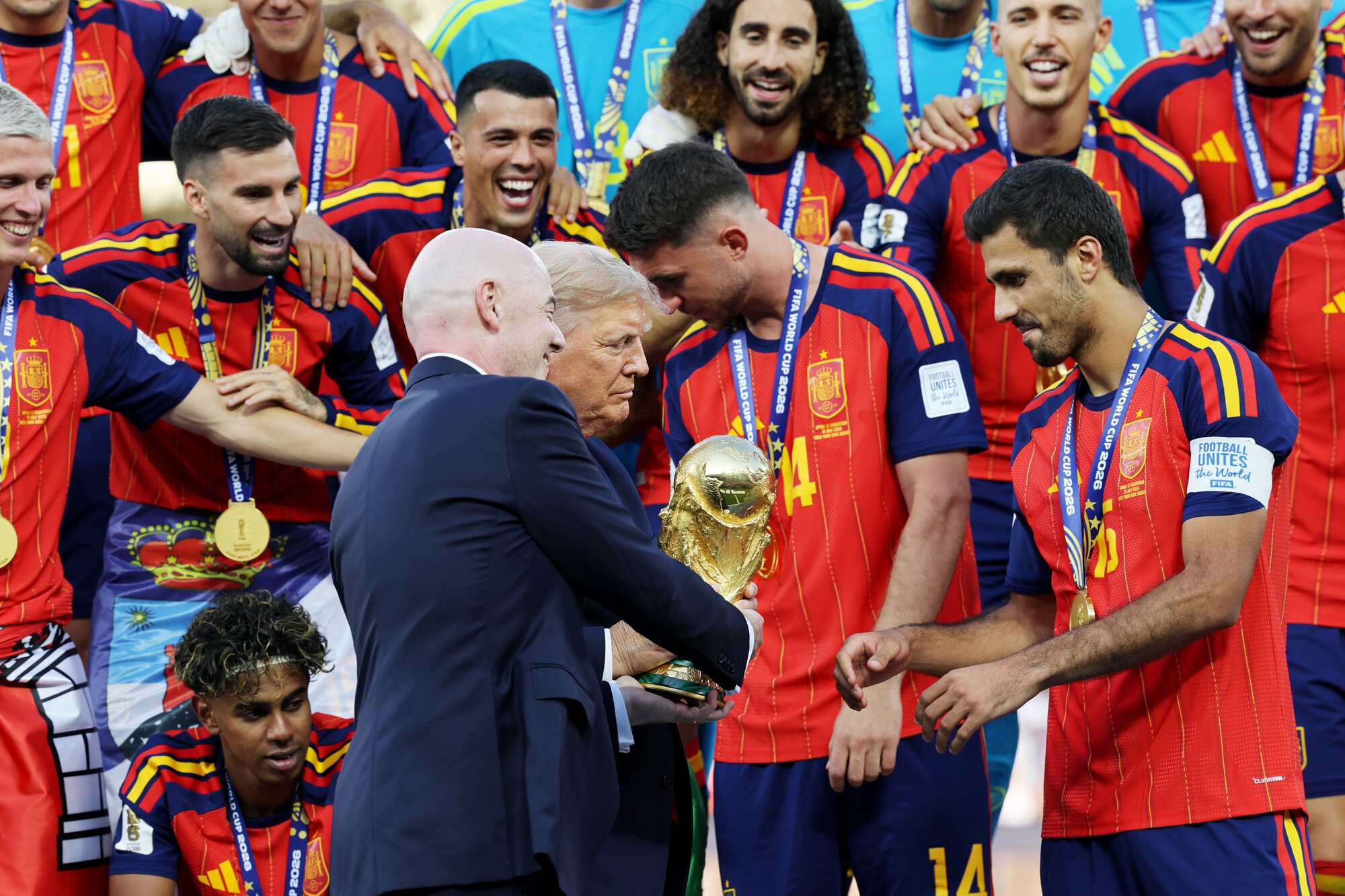 サッカーワールドカップ北中米大会の表彰式で優勝したスペインのロドリ(右)にワールドカップ優勝トロフィーを手渡すトランプ米大統領とFIFAのインファンティノ会長(手前)=内田光撮影