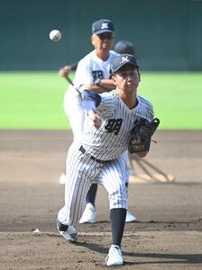 甲子園練習で投球する明徳義塾･田宮諒太郎、後方は馬淵史郎監督k(撮影･和賀正仁)