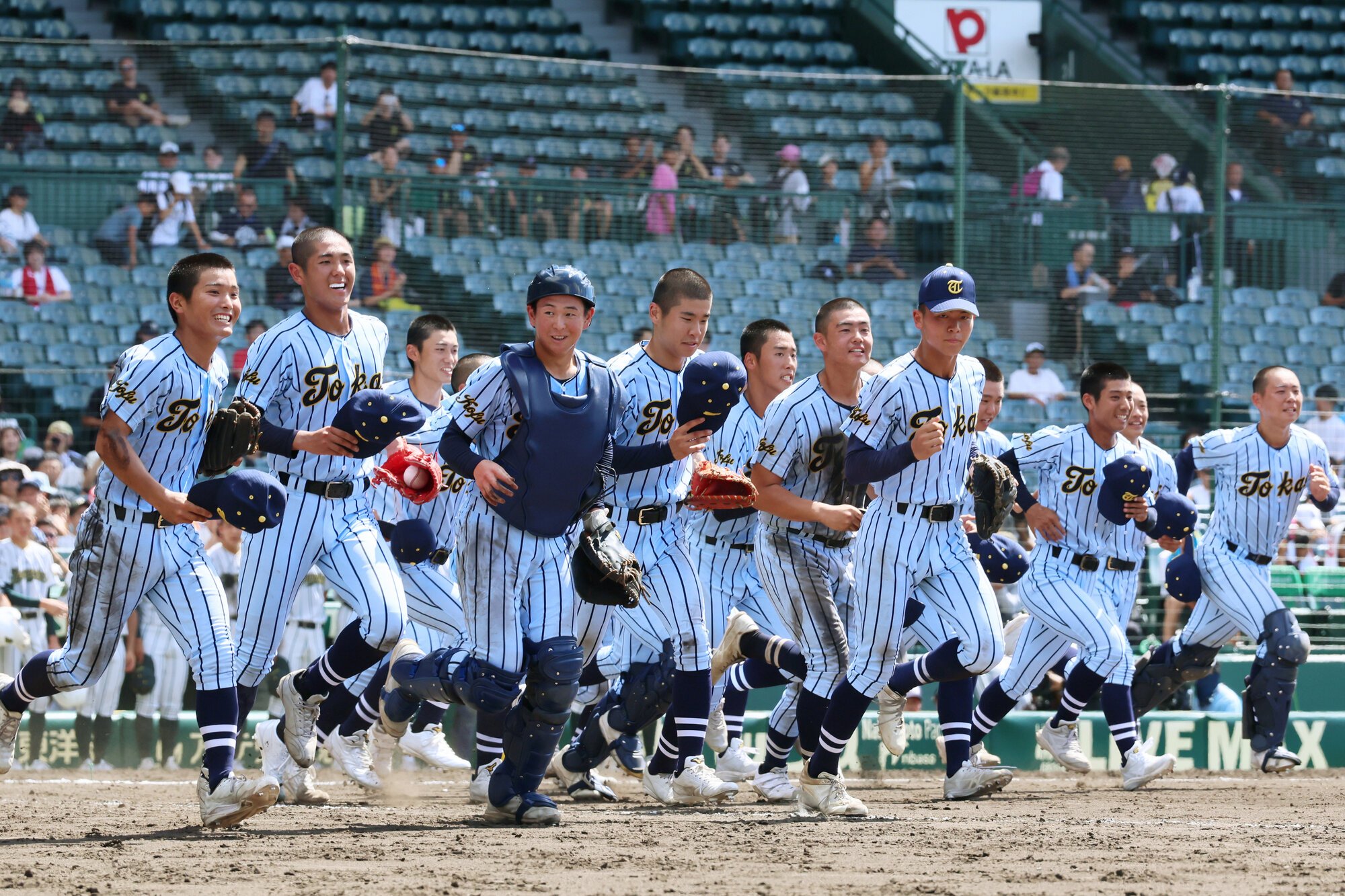 鶴岡東―東海大甲府　鶴岡東を破り、アルプス席へ駆け出す東海大甲府の選手たち=瀬戸口翼撮影