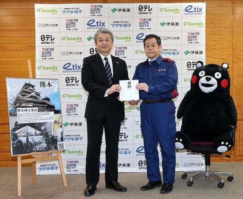 巨人の国松徹球団社長(左)が熊本県東京事務所の田口雄一所長(右)に計2000万円を寄付