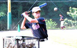 日南学園のグラウンドで外野手にノックを打つ、マネジャーの吉田翔蒼(とあ)さん=2026年7月25日、宮崎県日南市、吉田啓撮影
