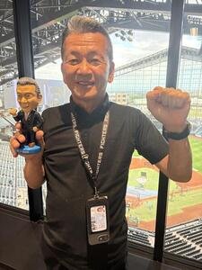 シャウエッセン改革に携わったメンバーから贈られた自身のポブルヘッドを手に笑顔の小村球団社長