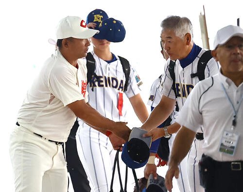 甲子園球場に入る智弁和歌山･中谷仁監督(左)と健大高崎･青柳博文監督は握手を交わして健闘を誓い合う(撮影･上田博志)