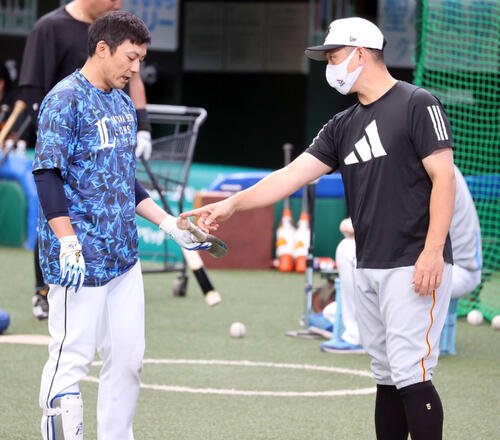 西武対巨人　試合前、巨人中島(右)と打撃談議する西武栗山(2022年6月撮影)