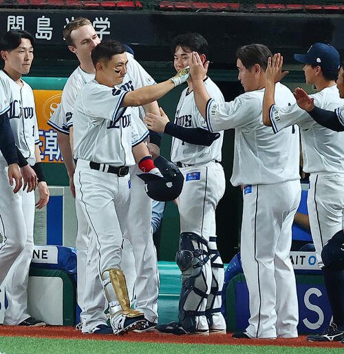 8回裏西武2死、中前安打を放った栗山巧は、交代し中村剛也(右)らに祝福される(撮影･野上伸悟)