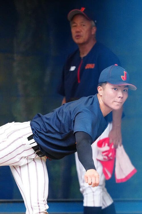 岡田龍生監督(後方)が見つめる中、ブルペン投球する福島陽奈汰(撮影･江口和貴)