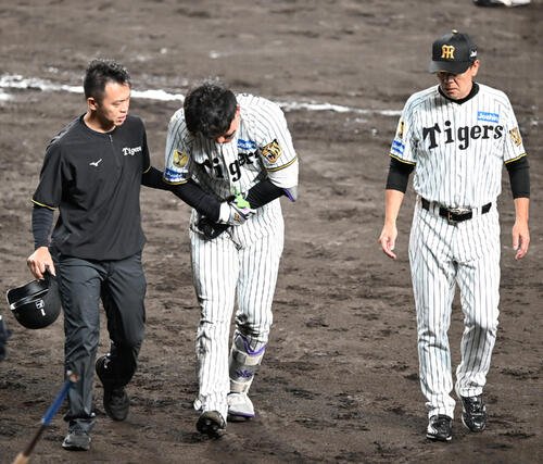 阪神対巨人　7回裏阪神1死、死球を受けた箇所を押さえながらベンチに下がる森下翔太(2026年8月撮影)