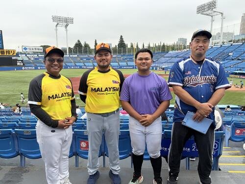 国学院大ー立正大を観戦するマレーシアのナショナルチームの(左から)アクマルコーチ、ウカハリコーチ、ハキム投手、大熊信夫コーチ(撮影･保坂淑子)