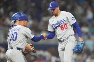 マーリンズ戦の8回、降板するドジャース･エンリケス(右)。左はロバーツ監督(AP)