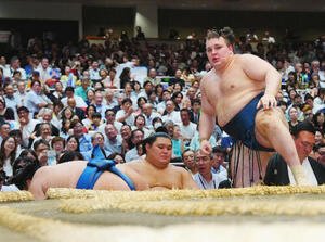 琴勝峰(左)を渡し込みで下す安青錦。中央は大の里(撮影･垰建太)