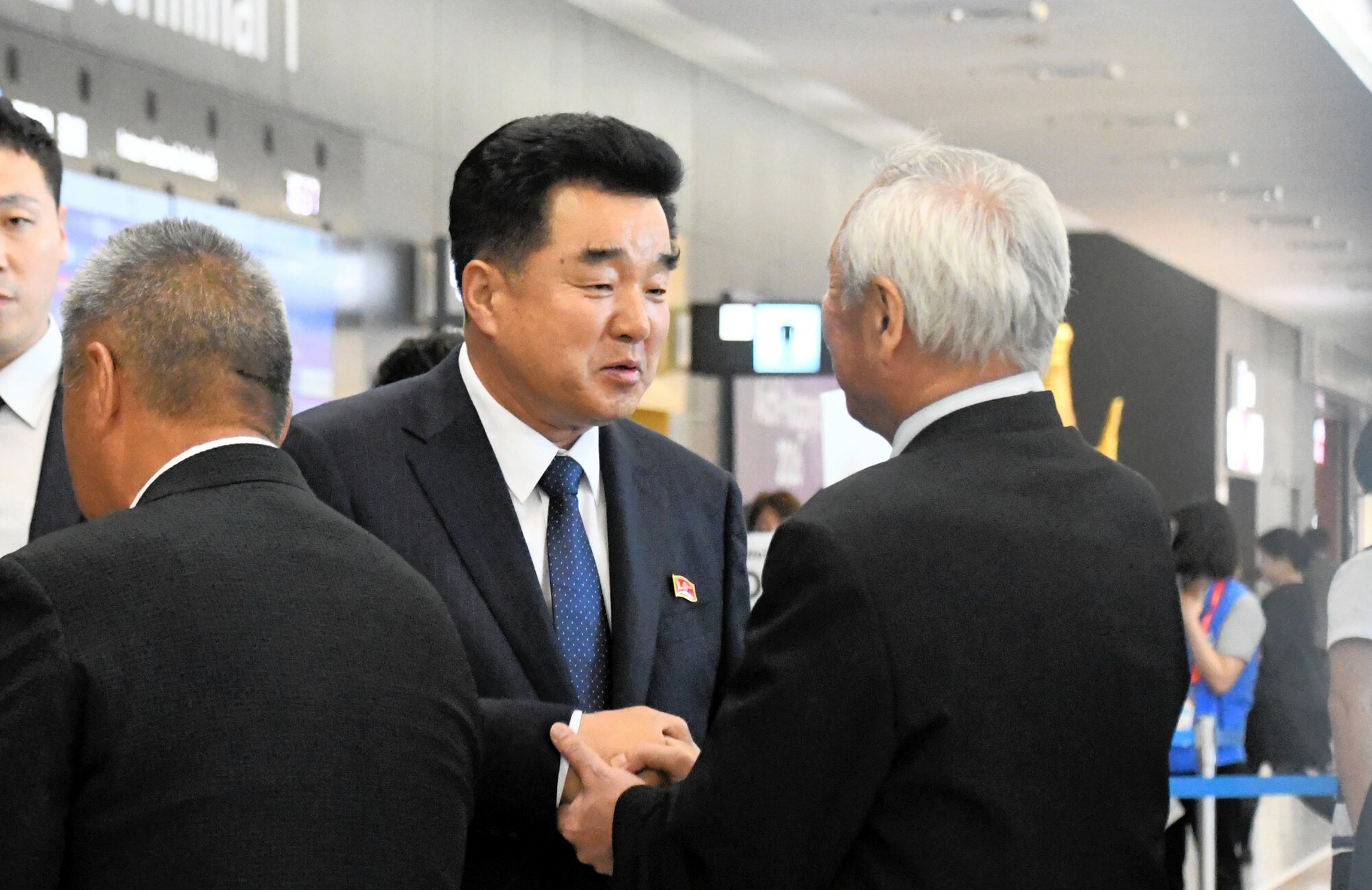 中部空港に到着後、関係者に出迎えられた北朝鮮の金日国体育相(中央)=2026年9月17日午後4時55分、愛知県常滑市、石垣明真撮影