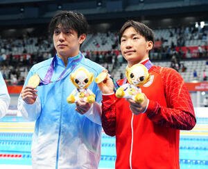 男子100メートル平泳ぎ決勝　同率1位で金メダルを獲得し、董志豪(左)と写真に納まる大橋信(撮影･鈴木みどり)