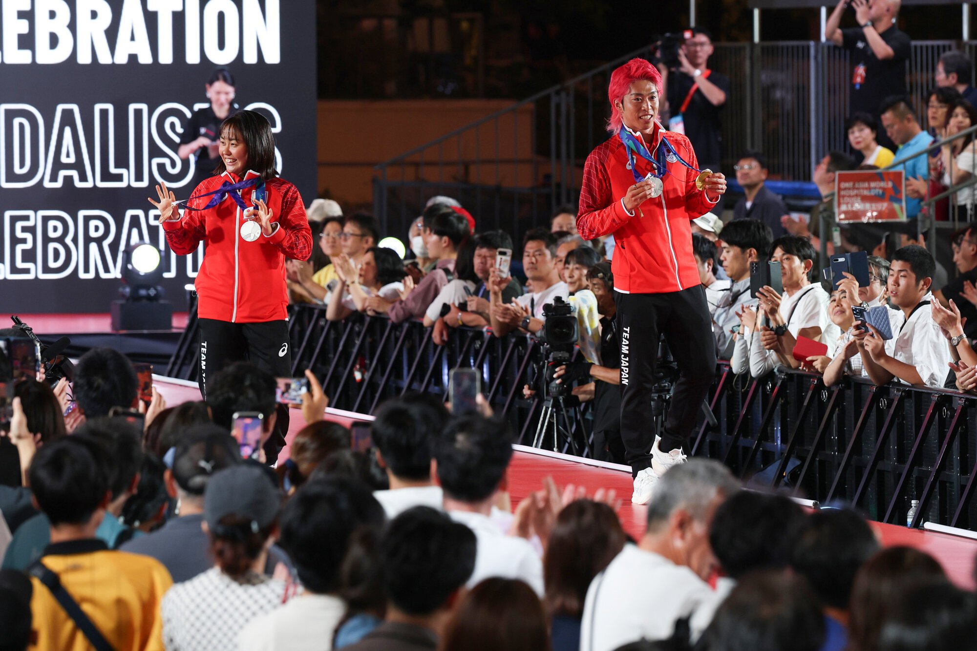 愛知･名古屋アジア大会　メダリストセレブレーションに登場したトライアスロン男子で金メダルを獲得した北條巧(右)とトライアスロン女子で銅メダルを獲得した林愛望=2026年9月21日午後6時3分、名古屋市中区、内海日和撮影
