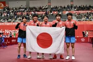 男子団体決勝　中国を破り優勝を決め日の丸を手に記念撮影する選手たち、左から篠塚大登、張本智和、岸川聖也監督、松島輝空、戸上隼輔(撮影･滝沢徹郎)
