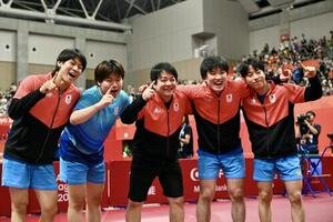 男子団体決勝　中国を破り優勝を決め記念撮影する選手たち。左から戸上隼輔、松島輝空、岸川聖也監督、張本智和、篠塚大登(撮影･滝沢徹郎)