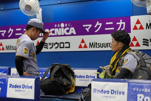 DeNA対阪神　試合後、ベンチに残り石井大智(左)に言葉を掛ける阪神坂本誠志郎(撮影･足立雅史)