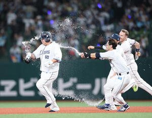西武対ロッテ　9回裏西武無死三塁、サヨナラ打を放った中村剛也(左)はナインから祝福のウォーターシャワーを浴びる(撮影･増田悦実)