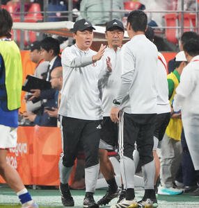 サッカー男子日本対北朝鮮　試合終了、日本大岩剛監督(左)はスタッフとタッチを交わす(撮影･森本幸一)