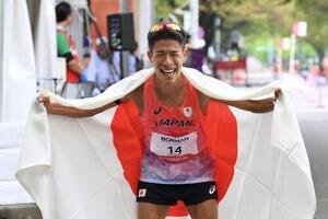 男子マラソン競歩で優勝を決めた勝木隼人は日の丸を背にポーズを決める(撮影･滝沢徹郎)