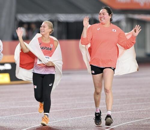 女子やり投げで準優勝の北口榛花(右)と銅メダルの武本紗栄は日の丸を背に場内を1周する(撮影･滝沢徹郎)