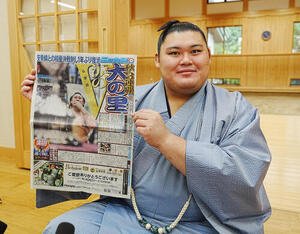 優勝一夜明け会見で1面で報じた本紙を手に笑顔を見せる大の里(撮影･小沢裕)