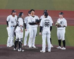ロッテ対ソフトバンク　1回表ソフトバンク1死、引退試合で登板を終えたロッテ唐川侑己(中央)はサブロー監督らナインからねぎらわれる(撮影･小沢裕)