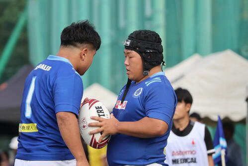東海大対法大　ライアウトのサイン交換をする東海大スローワーの川村航平(右)と佐々木天雅
