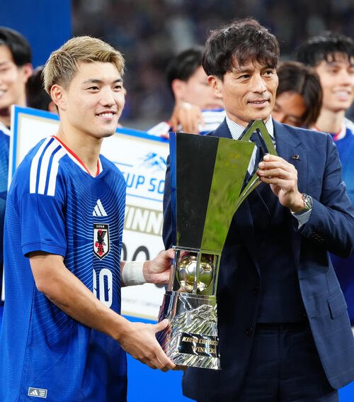 日本対ニュージーランド　キリン杯を手に日本サッカー協会宮本恒靖会長(右)と写真に納まる堂安律(撮影･江口和貴)