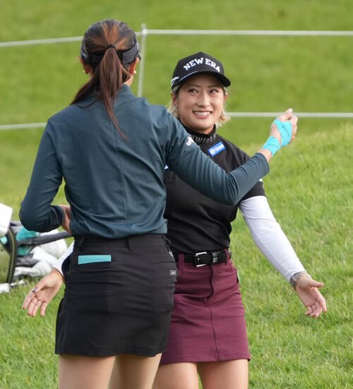 9番、首位タイで第1日を終え同伴競技者とハグする高橋しずく(撮影･小沢裕)
