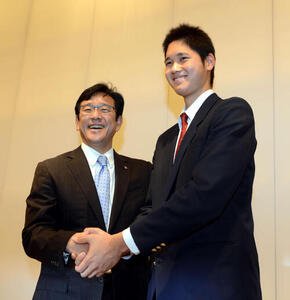記者会見で、日本ハム入りを正式に表明した大谷(右)は栗山監督と笑顔で握手をかわした(2012年12月9日撮影)