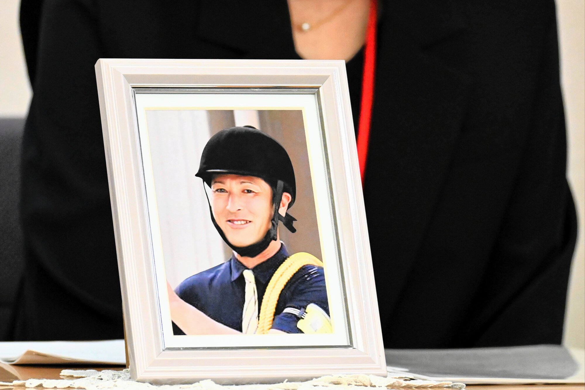 川崎競馬場の厩務(きゅうむ)員男性の自死について労災認定をうけ、遺影と共に涙ながらに会見で語る男性の母親=2026年10月22日午後0時11分、東京都千代田区、遠藤花撮影