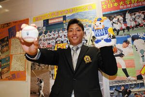 DeNAからドラフト1位指名を受けた大商大･星野世那はDeNAのボールと球団グッズを手に笑顔を見せる(撮影･宮崎幸一)
