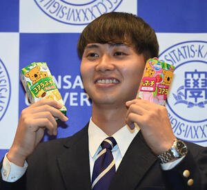 笑顔でロッテ｢コアラのマーチ｣を手にする関大･米沢友翔(撮影･和賀正仁)