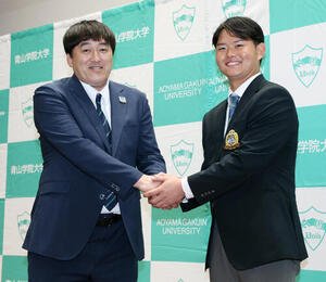 楽天石井一久GM(左)と笑顔で握手を交わすドラフト1位青学大･渡部海(撮影･宮地輝)