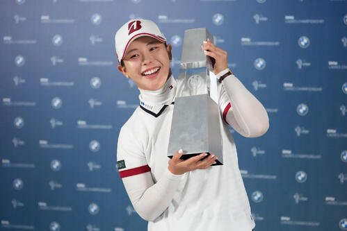 トロフィーを手に笑顔の吉田優利(AP)