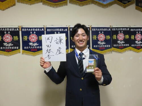ドラフト2位指名を受けた明大･岡田啓吾内野手(右)は楽天から指名挨拶を受け、ドラフト会議の入館証をもらってにっこり。｢謙虚｣と座右の銘をしたたため(撮影･斎藤直樹)