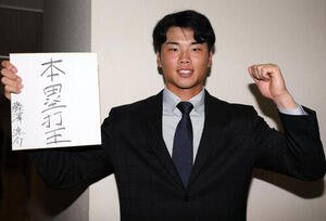 ヤクルトの指名あいさつを受けた東京ガスの藤沢涼介は色紙に｢本塁打王｣と抱負を書いてガッツポーズ(撮影･浅見桂子)