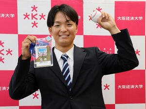 阪神ドラフト3位の大経大･常深颯大は、藤川球児監督のサインが入ったドラフト会議のパスとボールを手に笑顔を見せる(撮影･宮崎幸一)